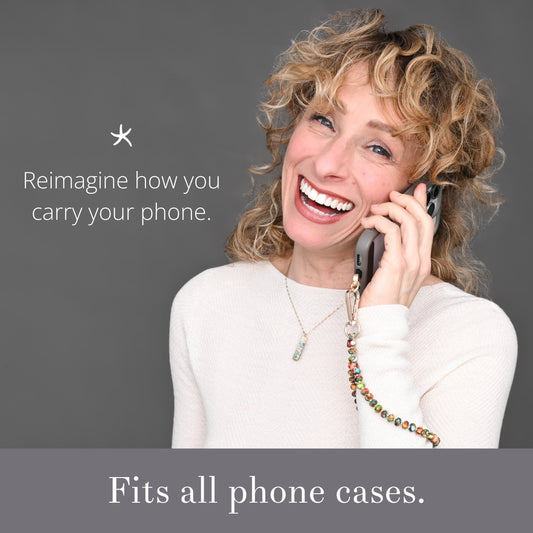 Smiling woman on the phone using a Sedona beaded wrist strap with text about phone cases