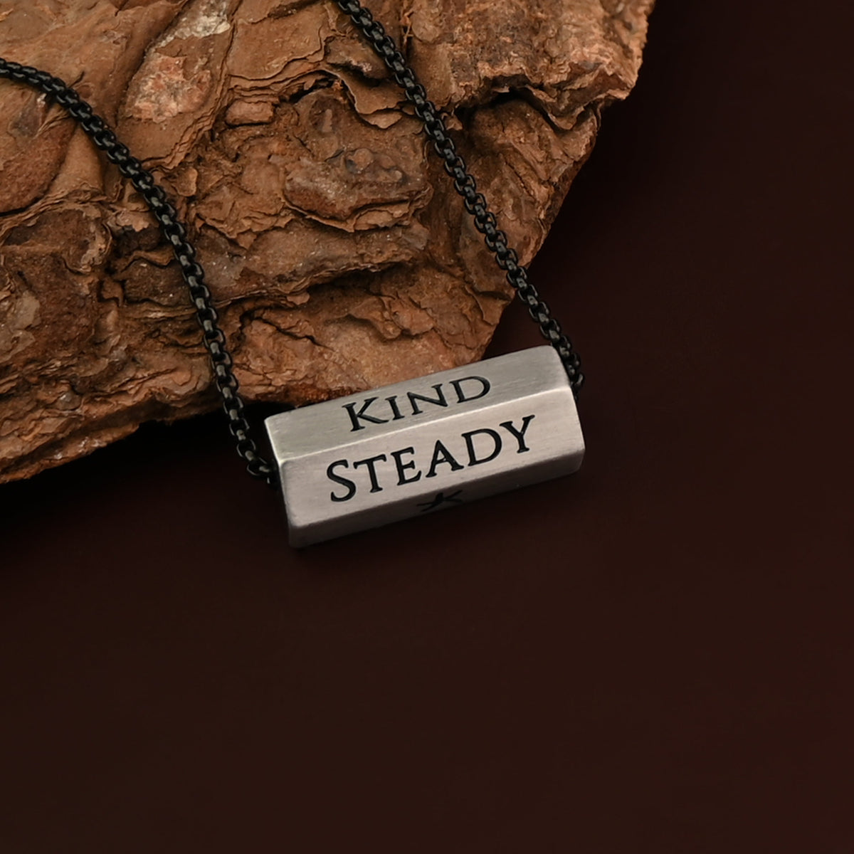 Pillar silver bar pendant engraved Kind and Steady on brown rock
