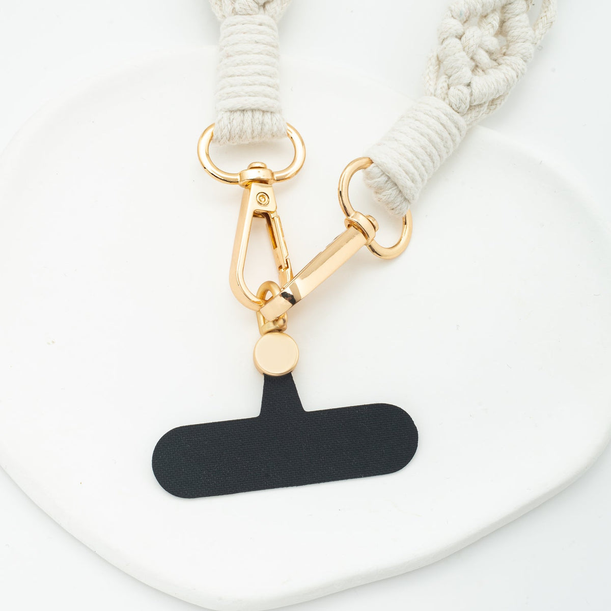 Wear Hope macramé strap gold clasps attached to a black phone tether tab