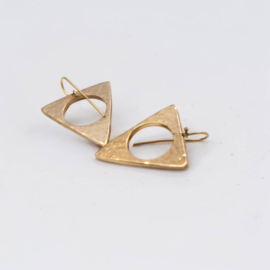 Lia hammered hollow triangle earrings flat lay showing texture