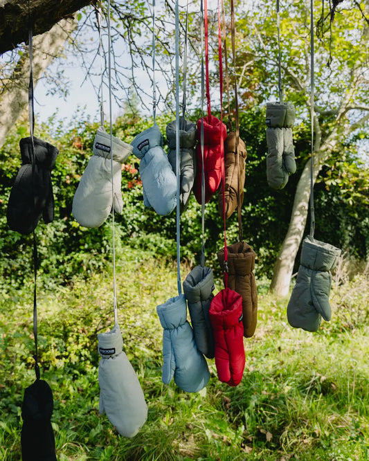 Navy blue vegan winter gloves made from recycled materials hanging outdoors on strings. - The New Orchard - Navy Blue