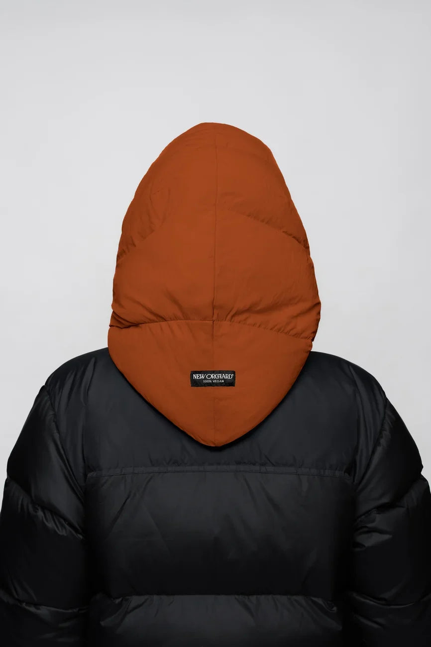 Vegan cinnamon-colored winter capuche made from recycled materials on black puffer jacket back. - The New Orchard - Fresh Cinnamon