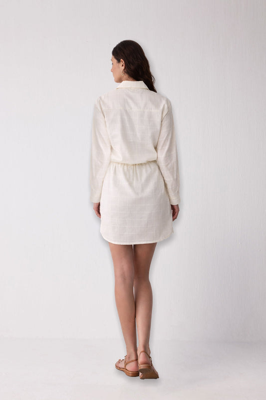 Person wearing a white outfit against a plain background