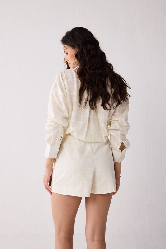 Woman wearing a white shorts against a plain background