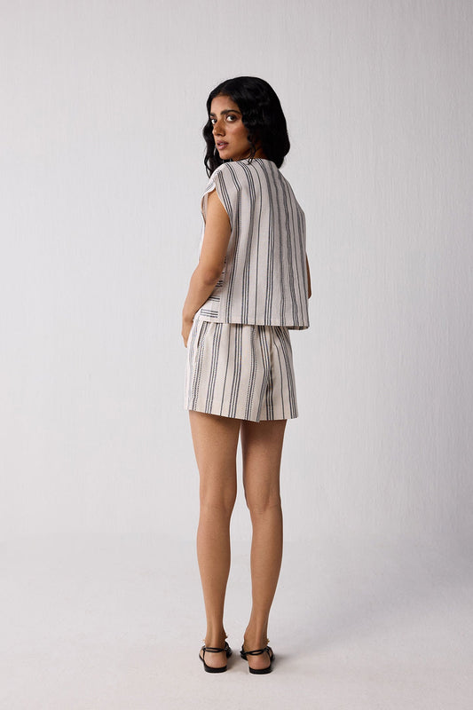 Woman wearing a striped outfit on a plain background
