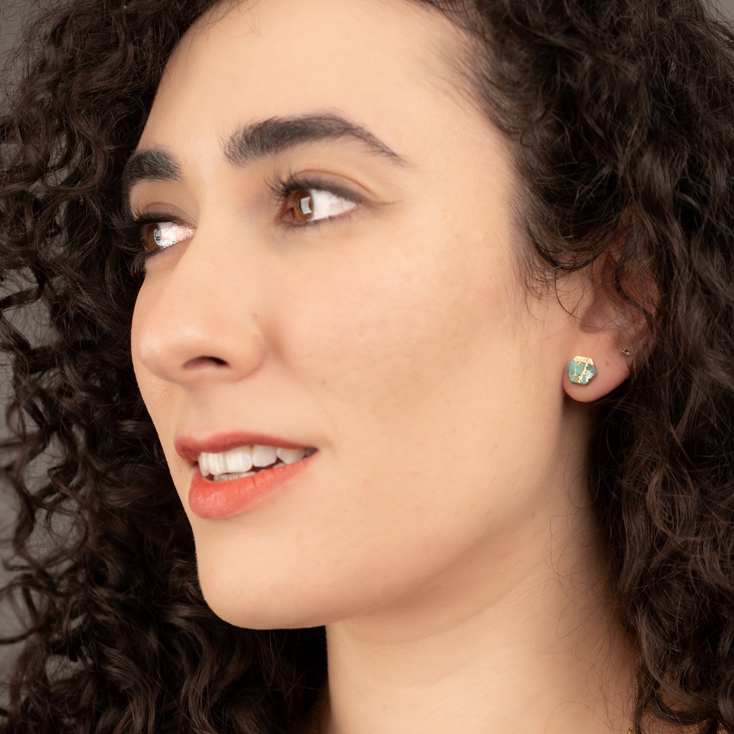 A woman wearing high quality, fashion women's jewelry, turquoise and gold stud earrings, best presents online jewelry