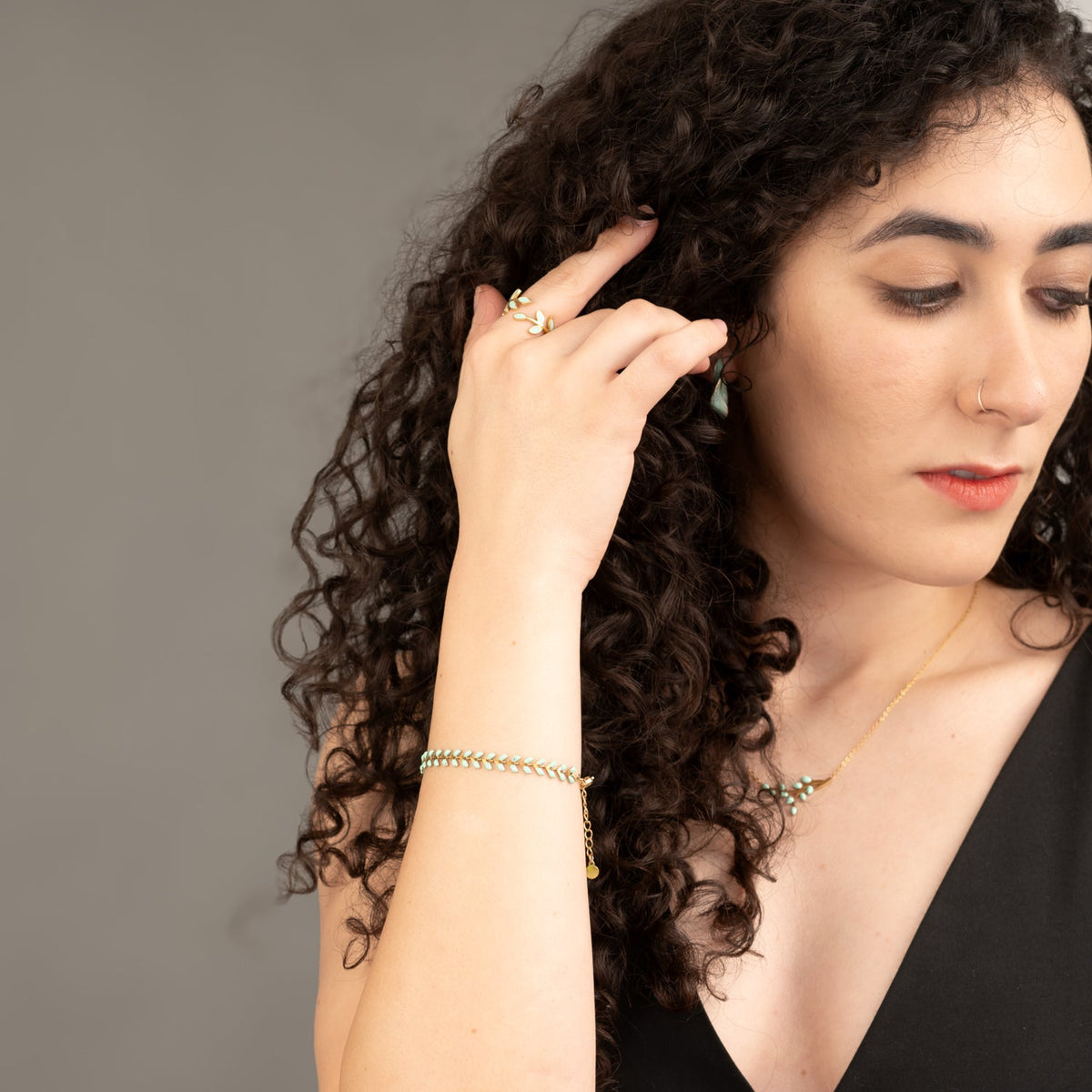Model in a black top wearing Seeds of Hope mint leaf ring
