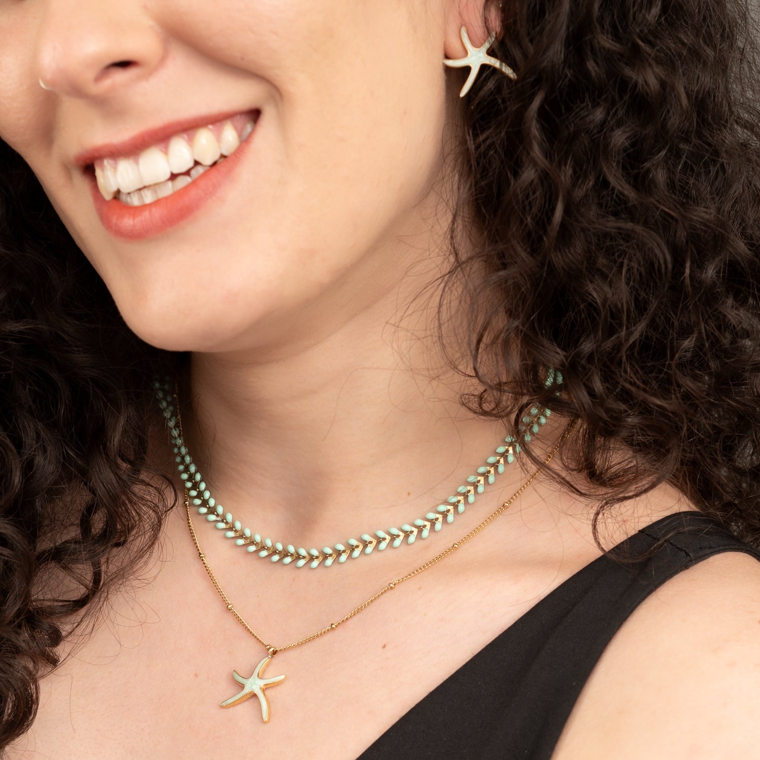 Woman wearing matching starfish themes jewelry set, mint green jewelry pieces, jewelry websites for women