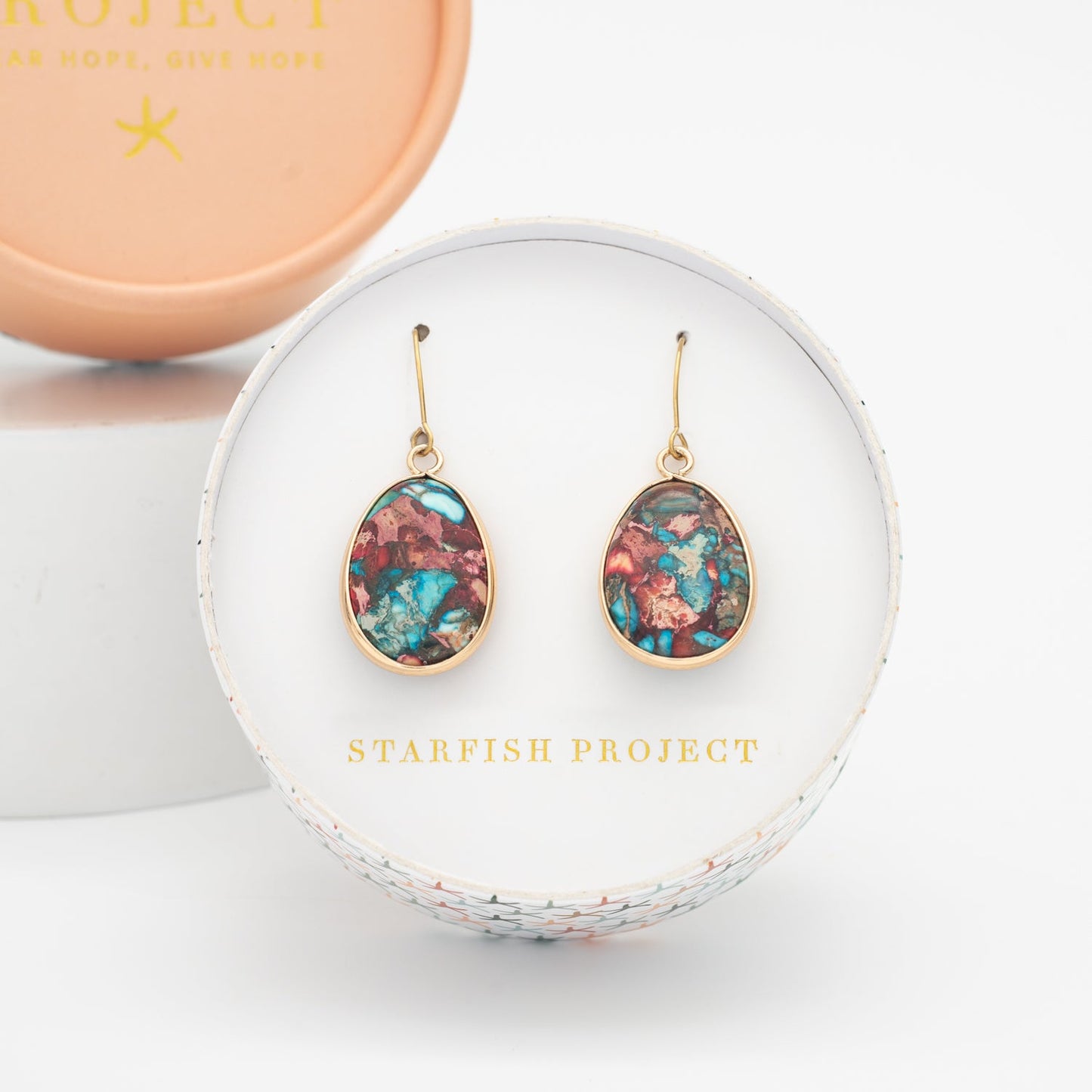 Set of gold shaded and colorful jasper earrings in a round white box with jewelry company name, Starfish Project, fair trade stores online, special Christmas gift ideas