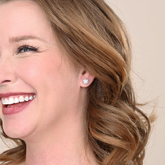 A woman wearing shiny, quality, silver studs, silver wedding day studs, high end silver earrings