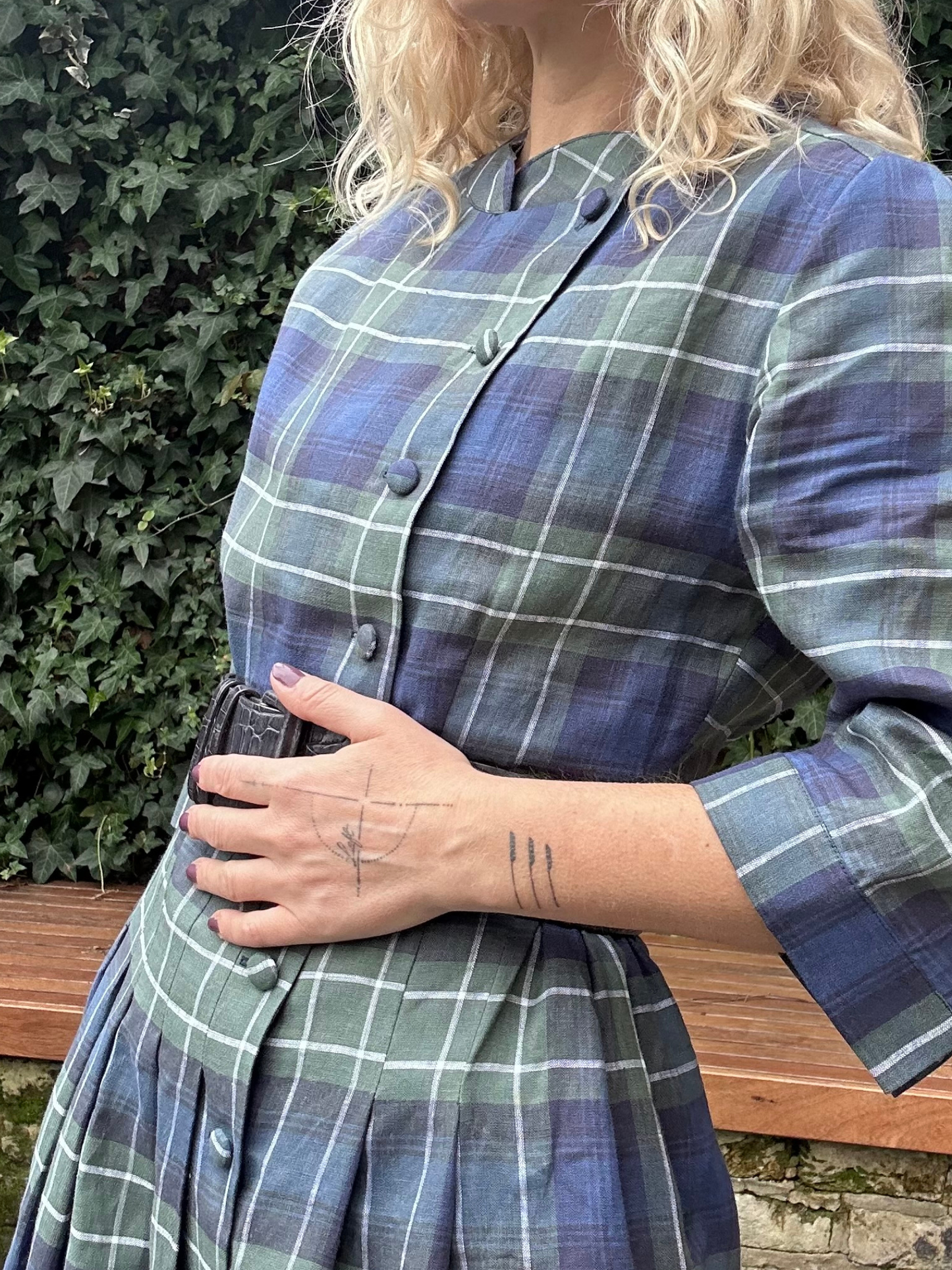 Person wearing a blue and green plaid dress with a blurred background
