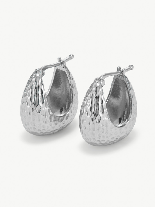 Pair of silver hoop hammered earrings on a white background
