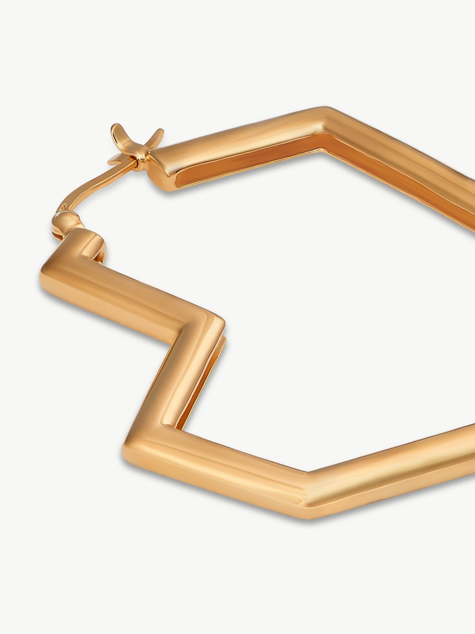 Gold hexagonal hoop earring on a white background