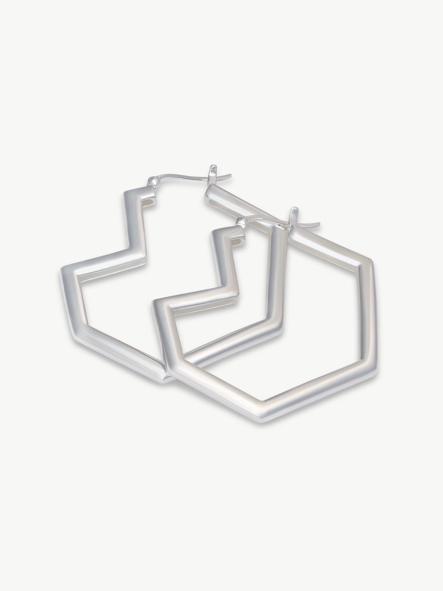 Set of silver heart hoop earrings on a white background