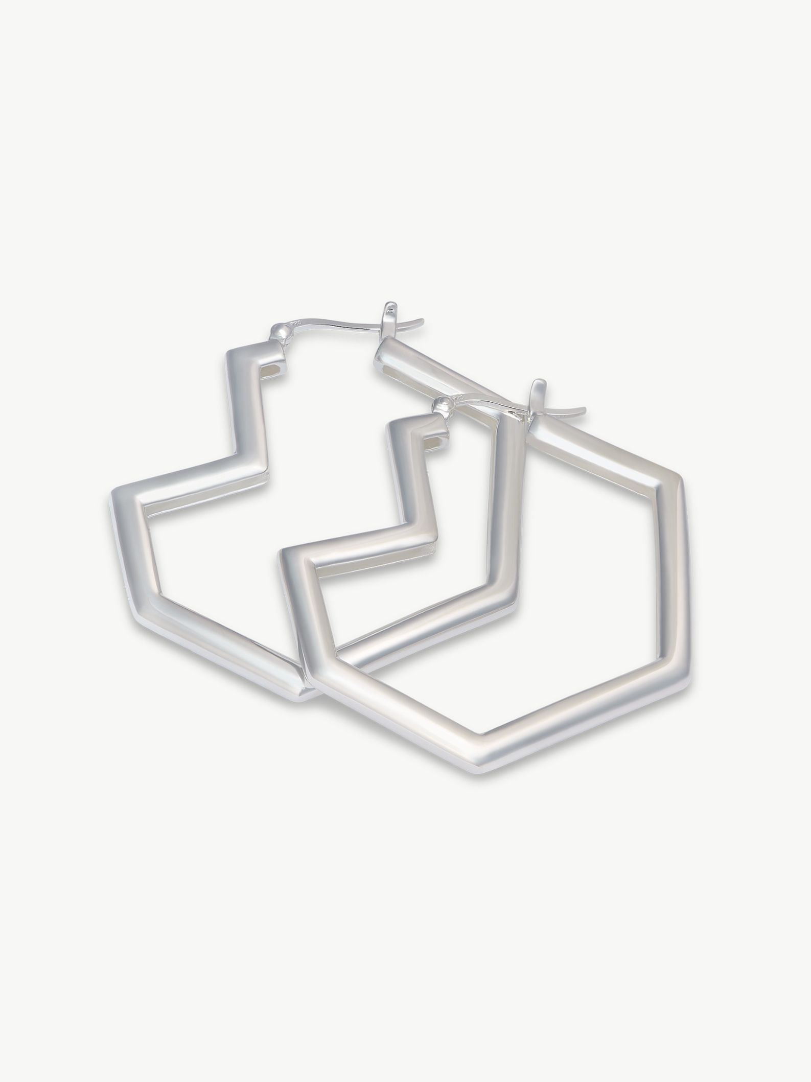 Set of silver heart hoop earrings on a white background