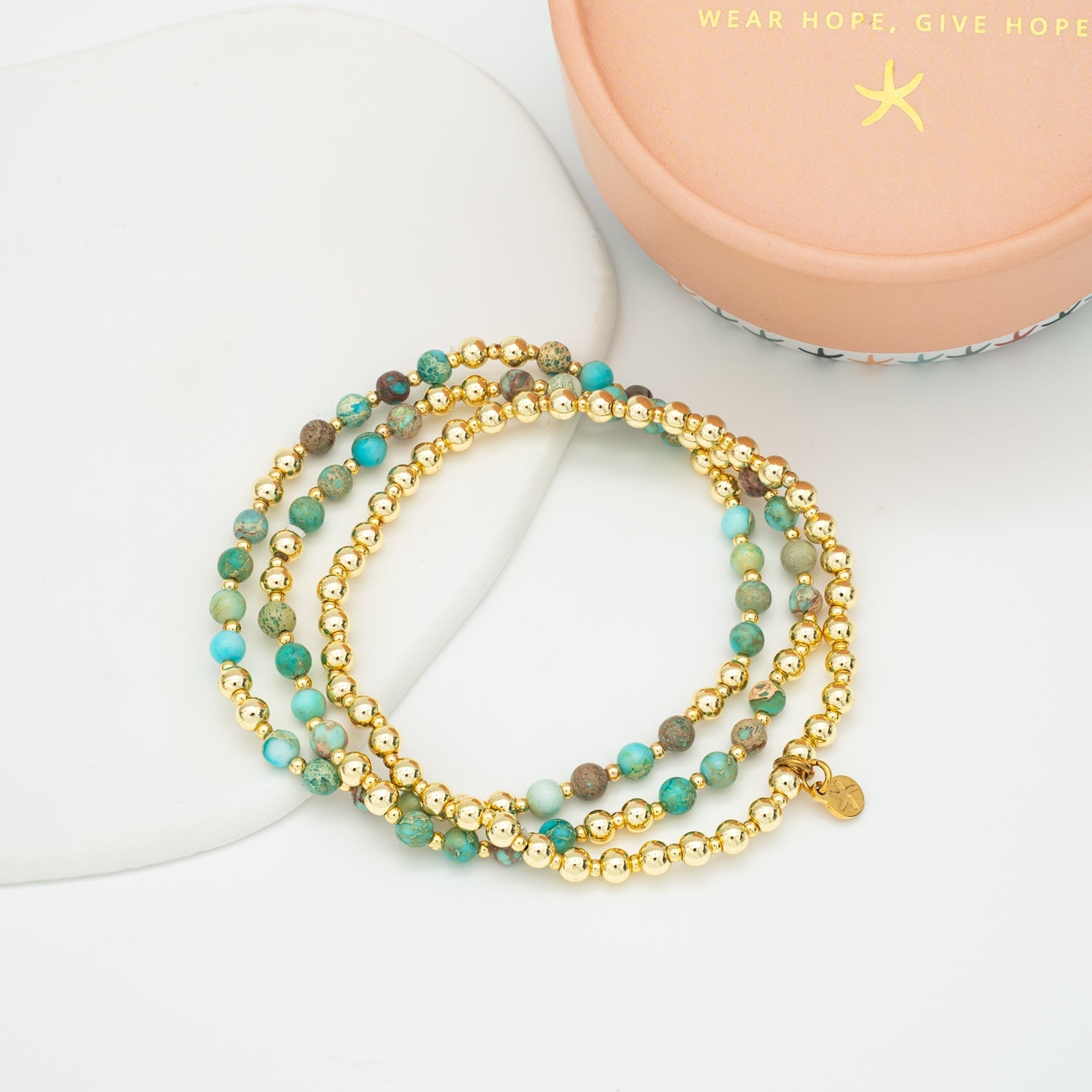 Stackable bracelets beside Starfish Project gift box, cute colorful bracelets, golds, jewelry website, gift ideas for Christmas