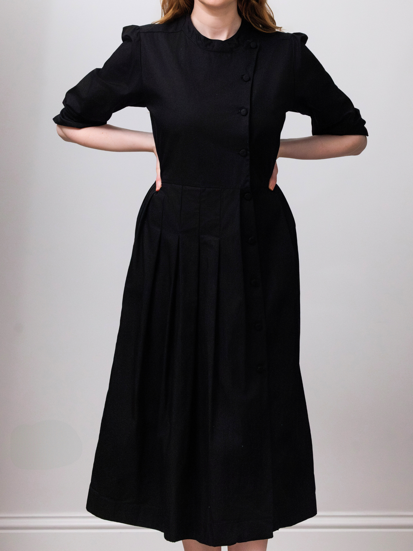 Person wearing a black dress with a white background