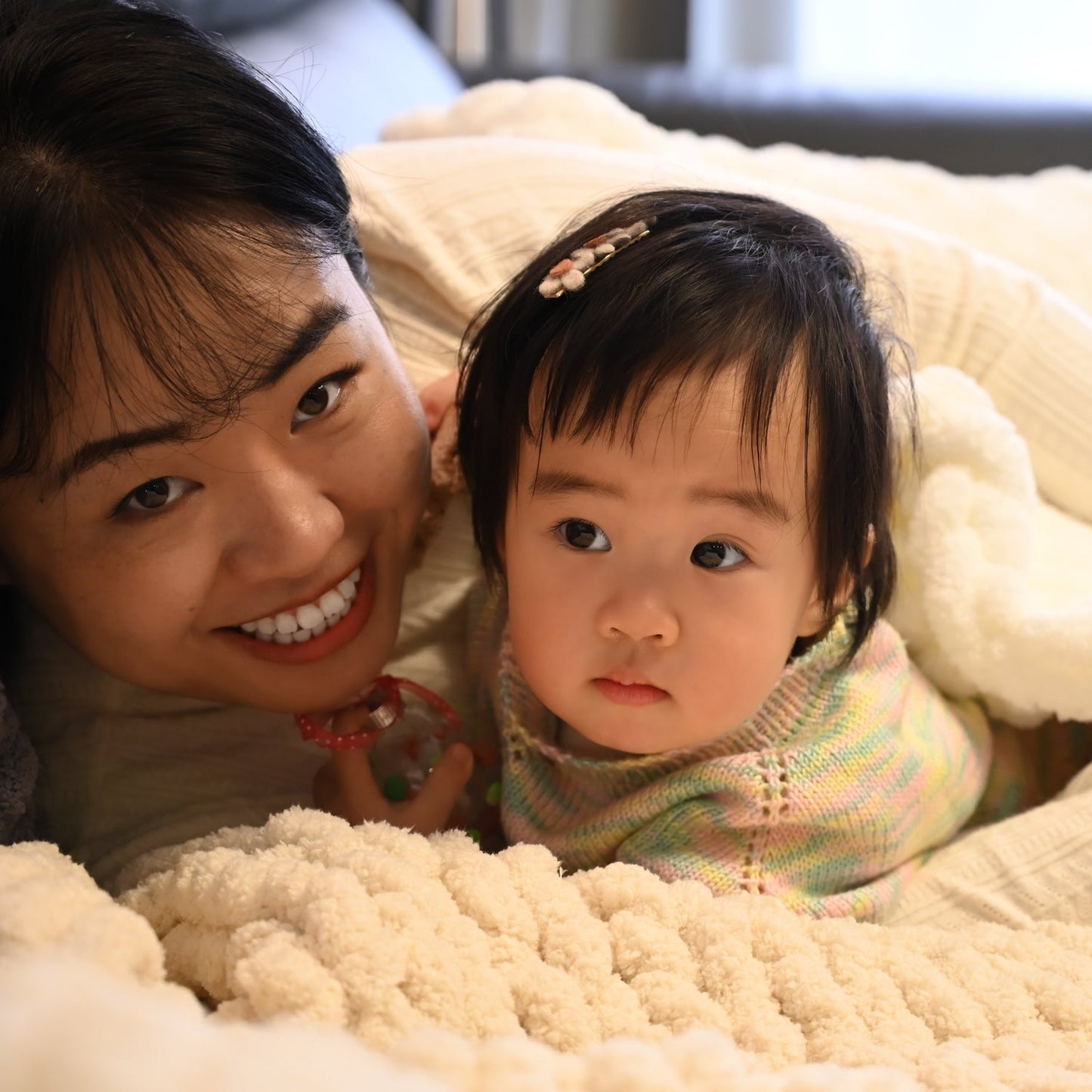 A photo of a mother and daughter in beautifully hand made baby blanket, special mother's day present