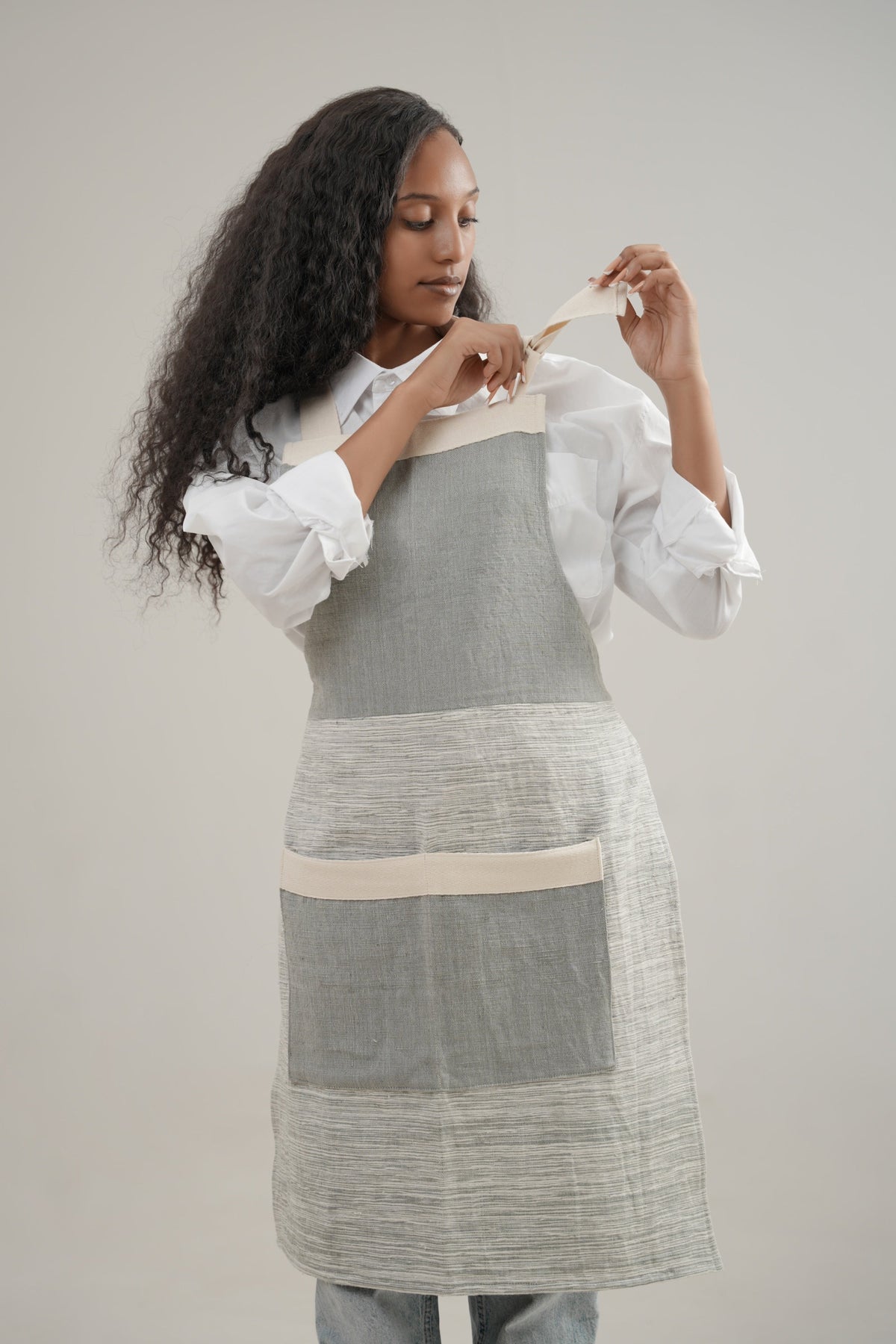Apron in grey on ethiopian model with white background