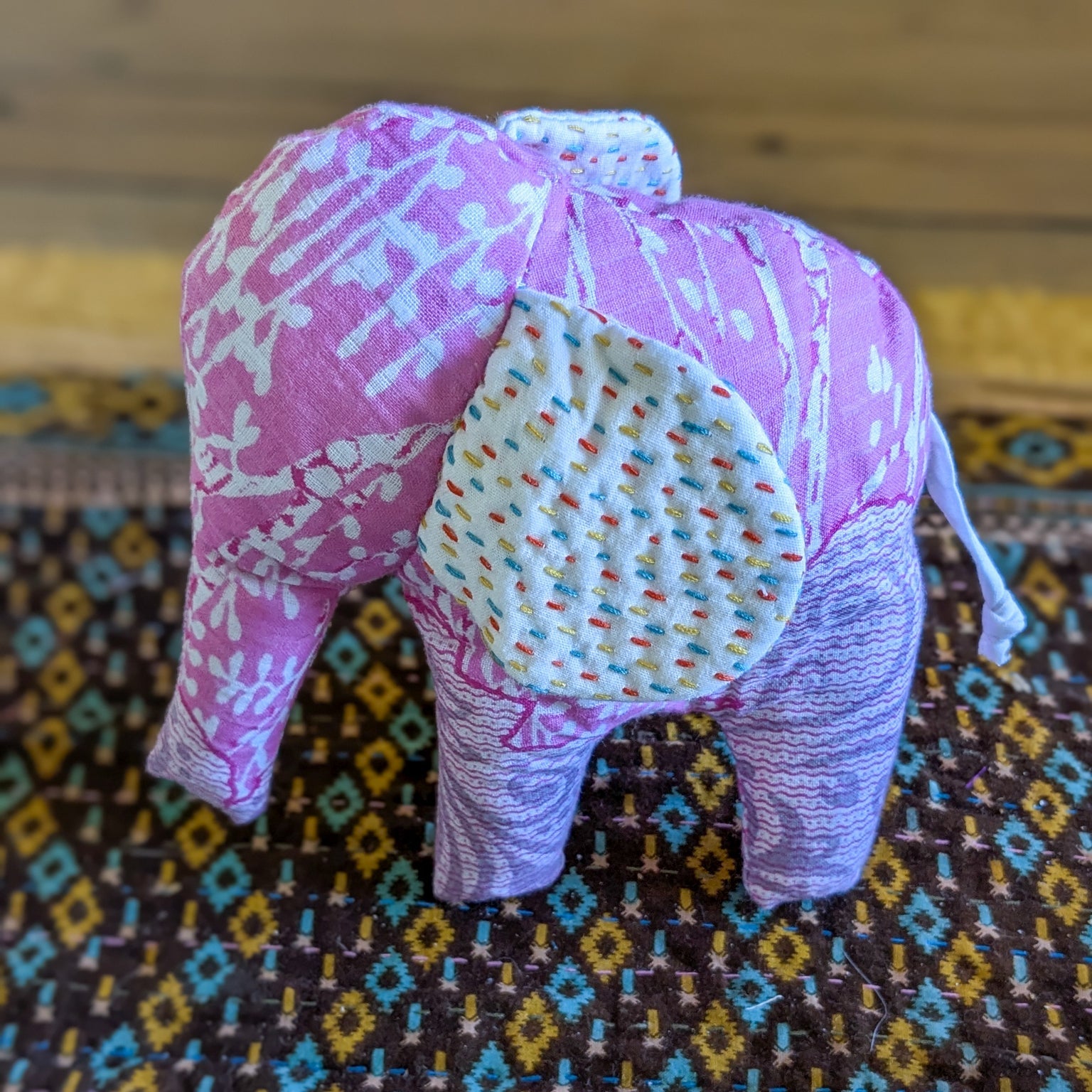 Fabric elephant on a patterned fabric background