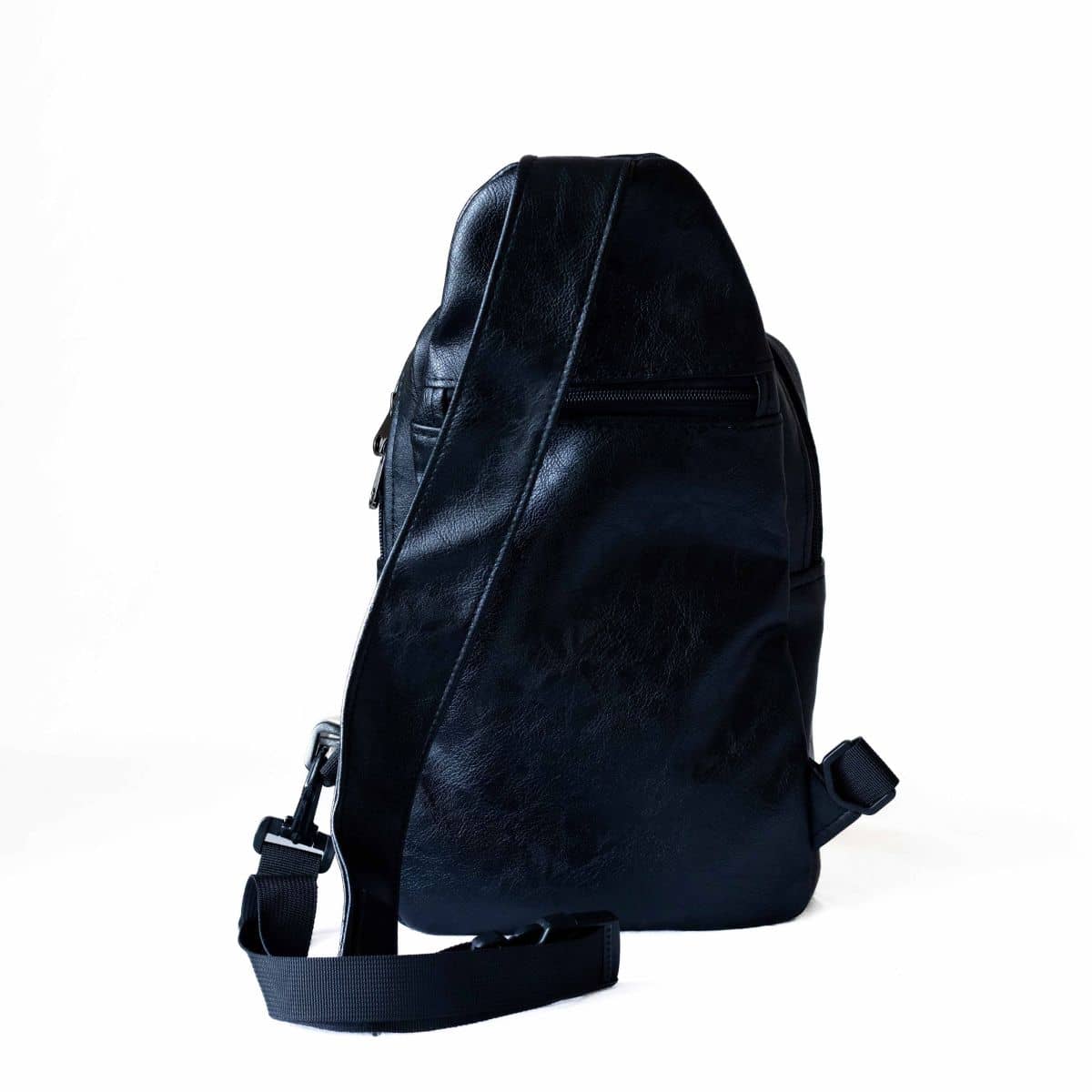 Umoja black vegan leather sling bag worn crossbody #color_black