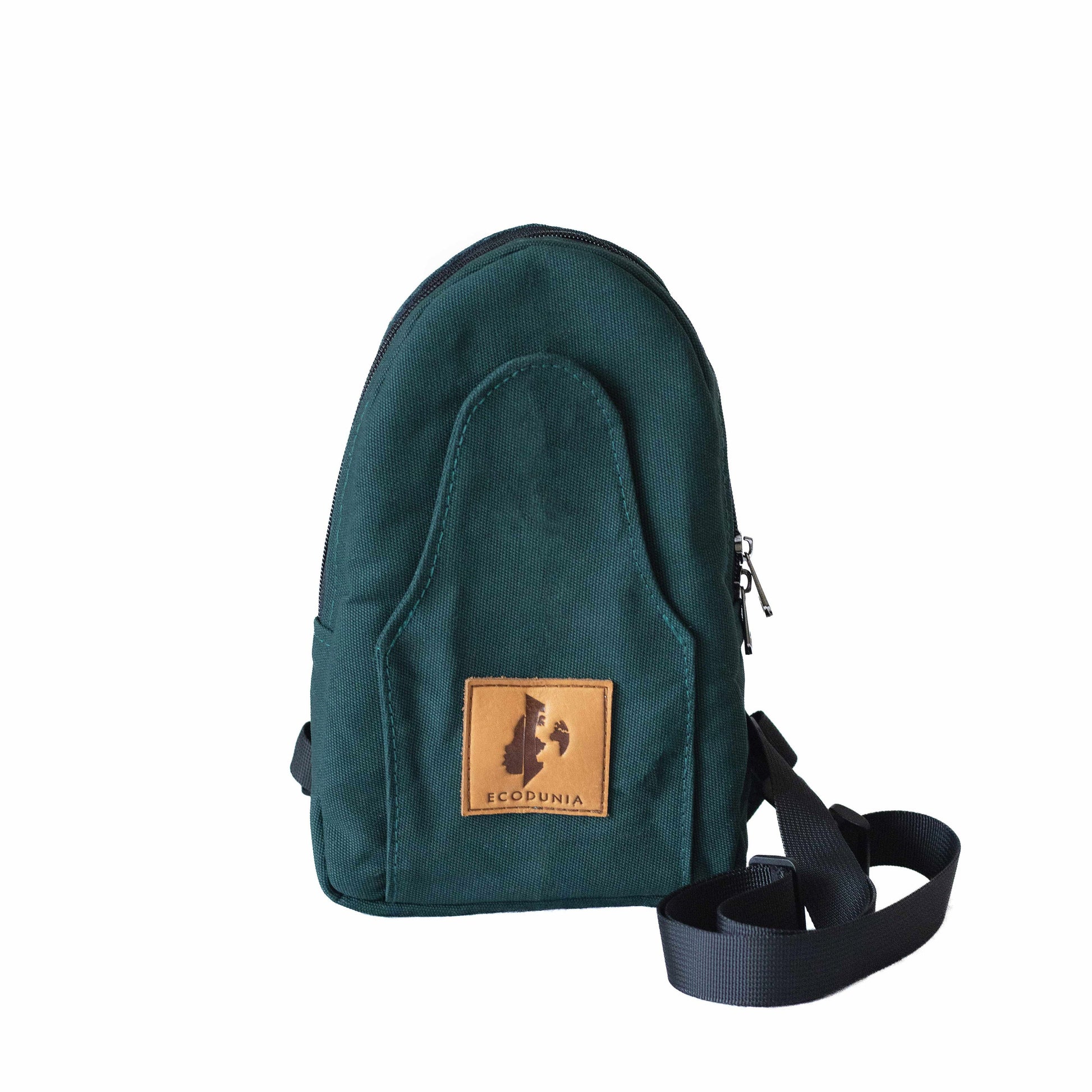 Buru canvas sling bag in forest green worn crossbody #color_forest-green