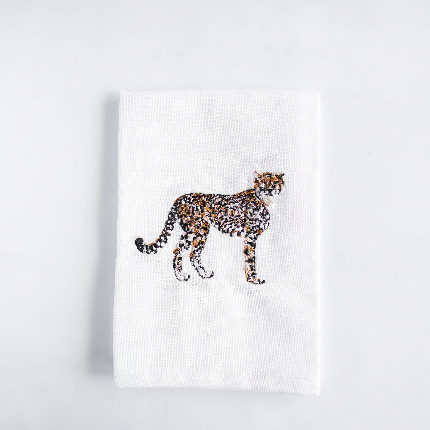 Cheetah embroidered cotton cloth napkin on white surface