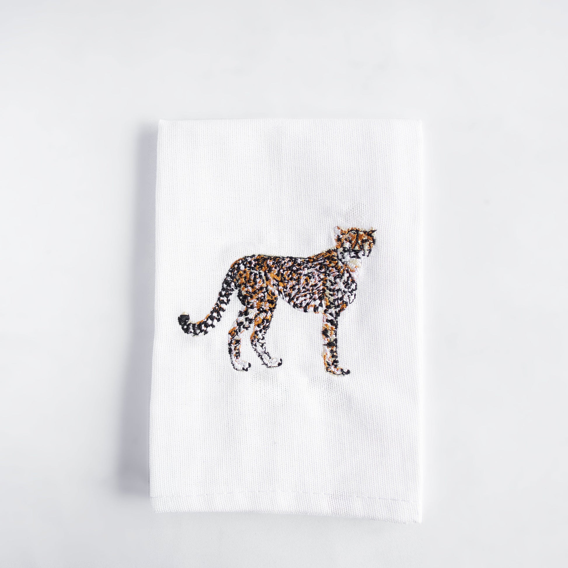 Cheetah embroidered cotton cloth napkin on white surface