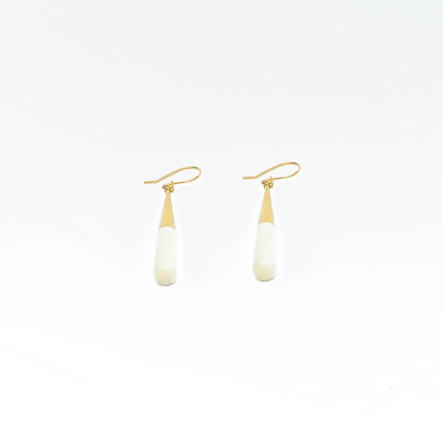Guru white horn brass drop earrings worn showing natural variation
