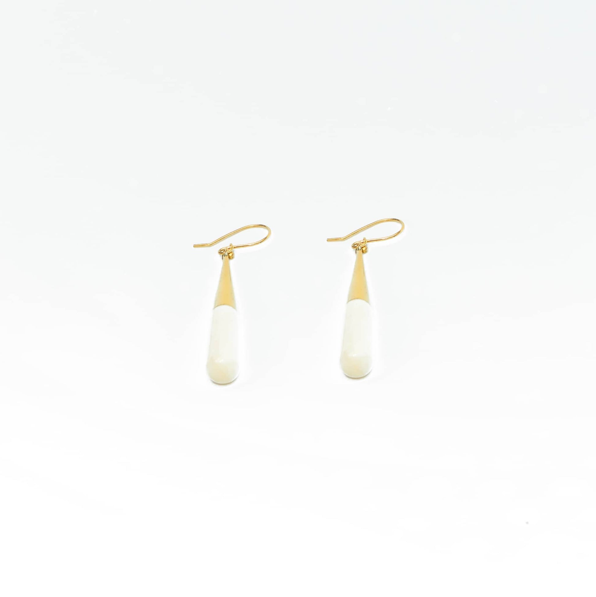Guru white horn brass drop earrings worn showing natural variation
