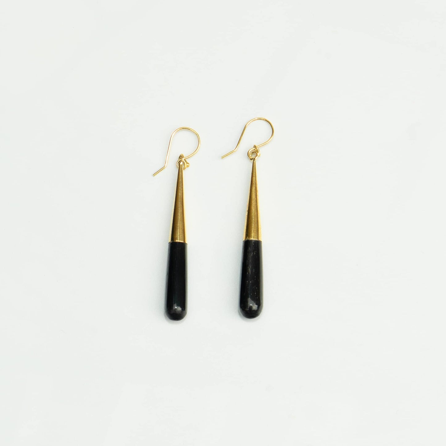 Guru black horn brass drop earrings worn showing material contrast