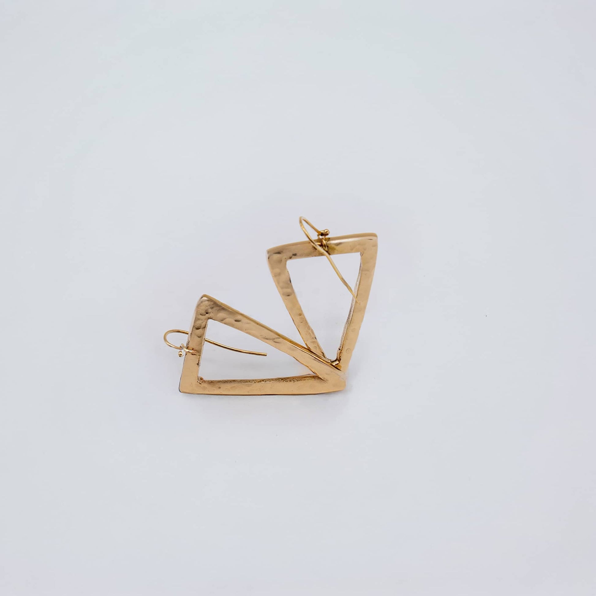 Lani brass open triangle earrings worn showing geometric frame