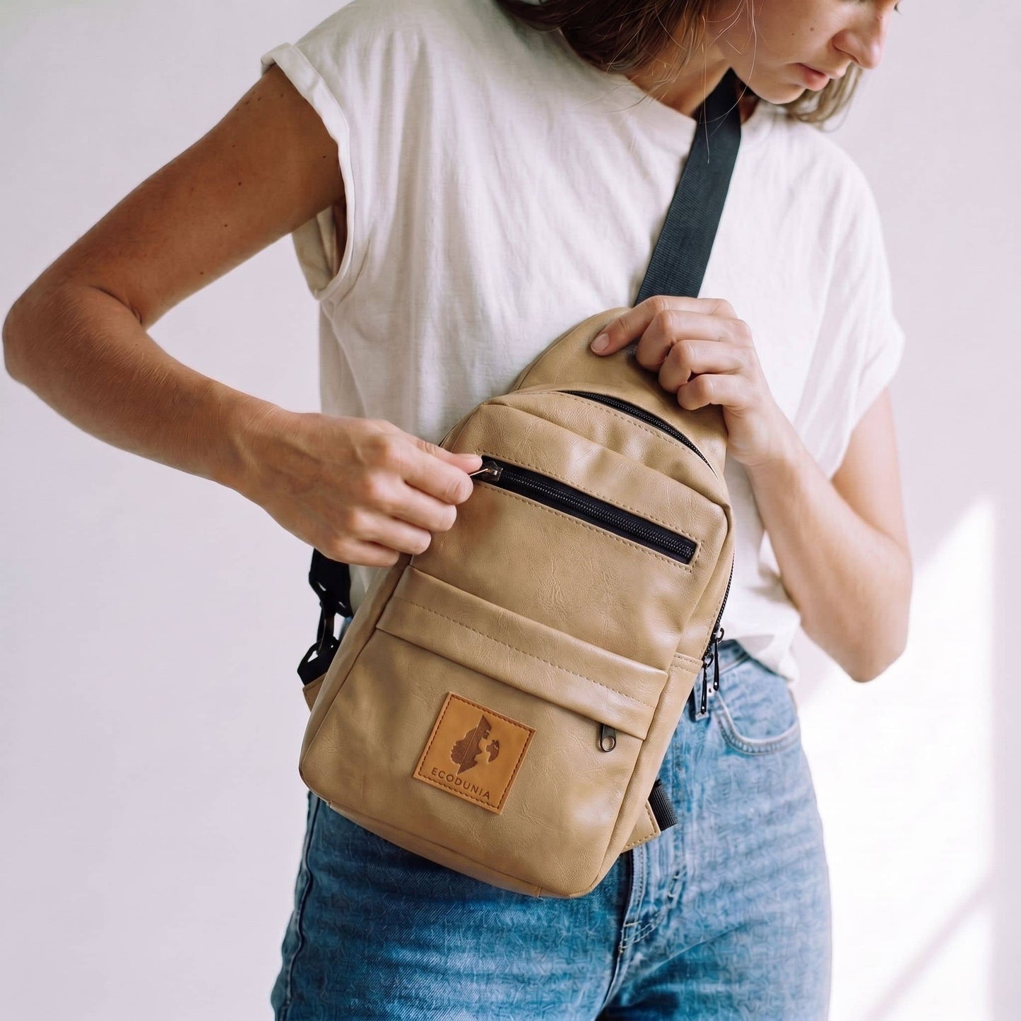Umoja latte vegan leather sling bag flat lay #color_latte
