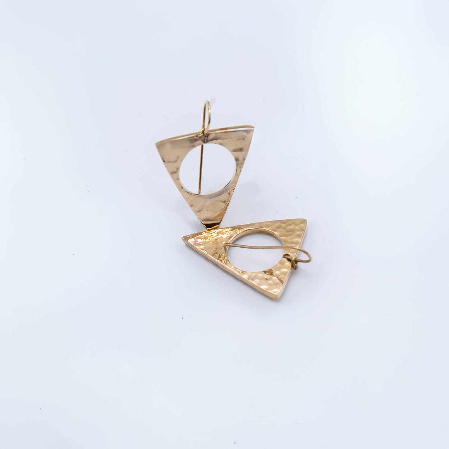 Lia brass triangle drop earrings worn on ear showing shape