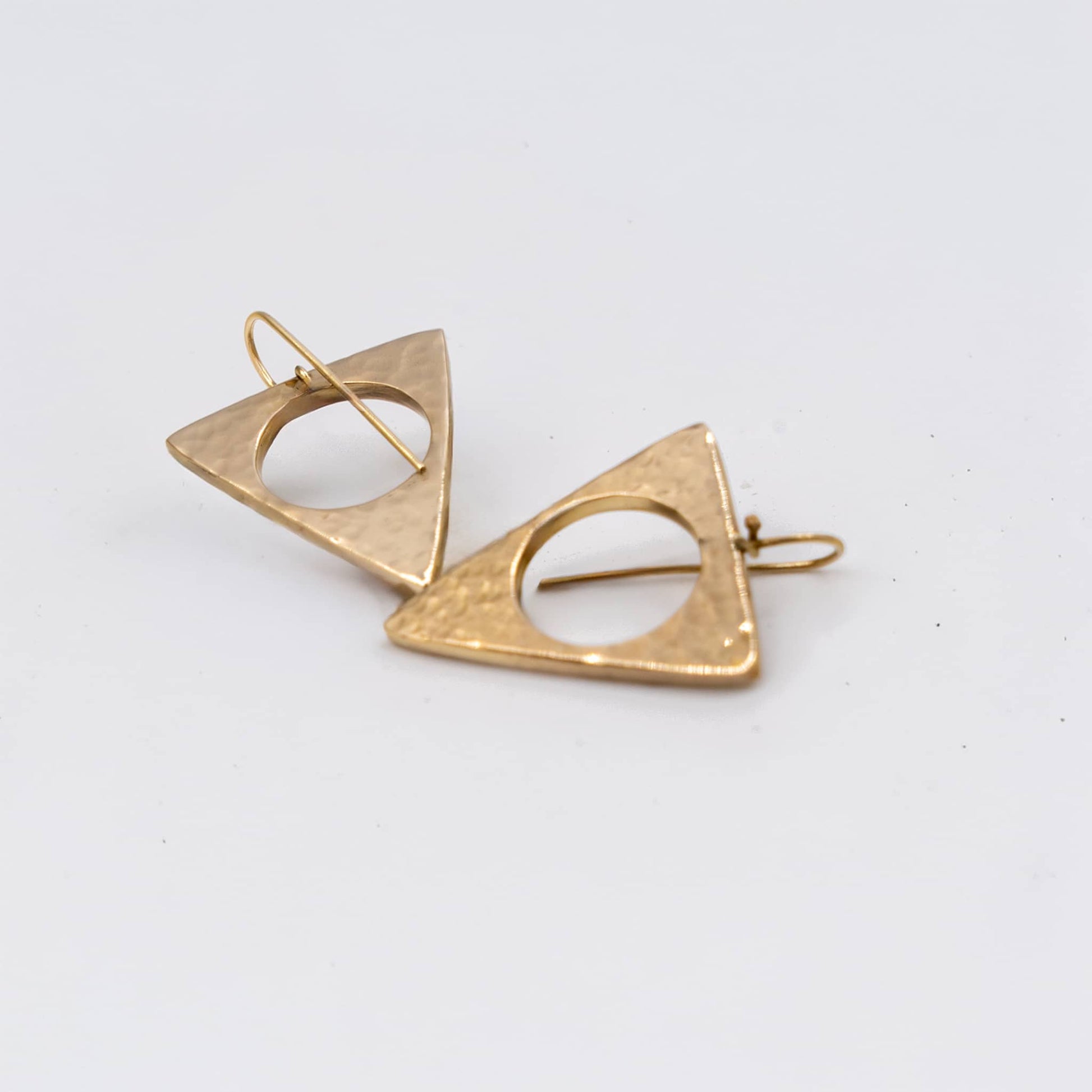 Lia hammered triangle brass earrings worn showing geometric form