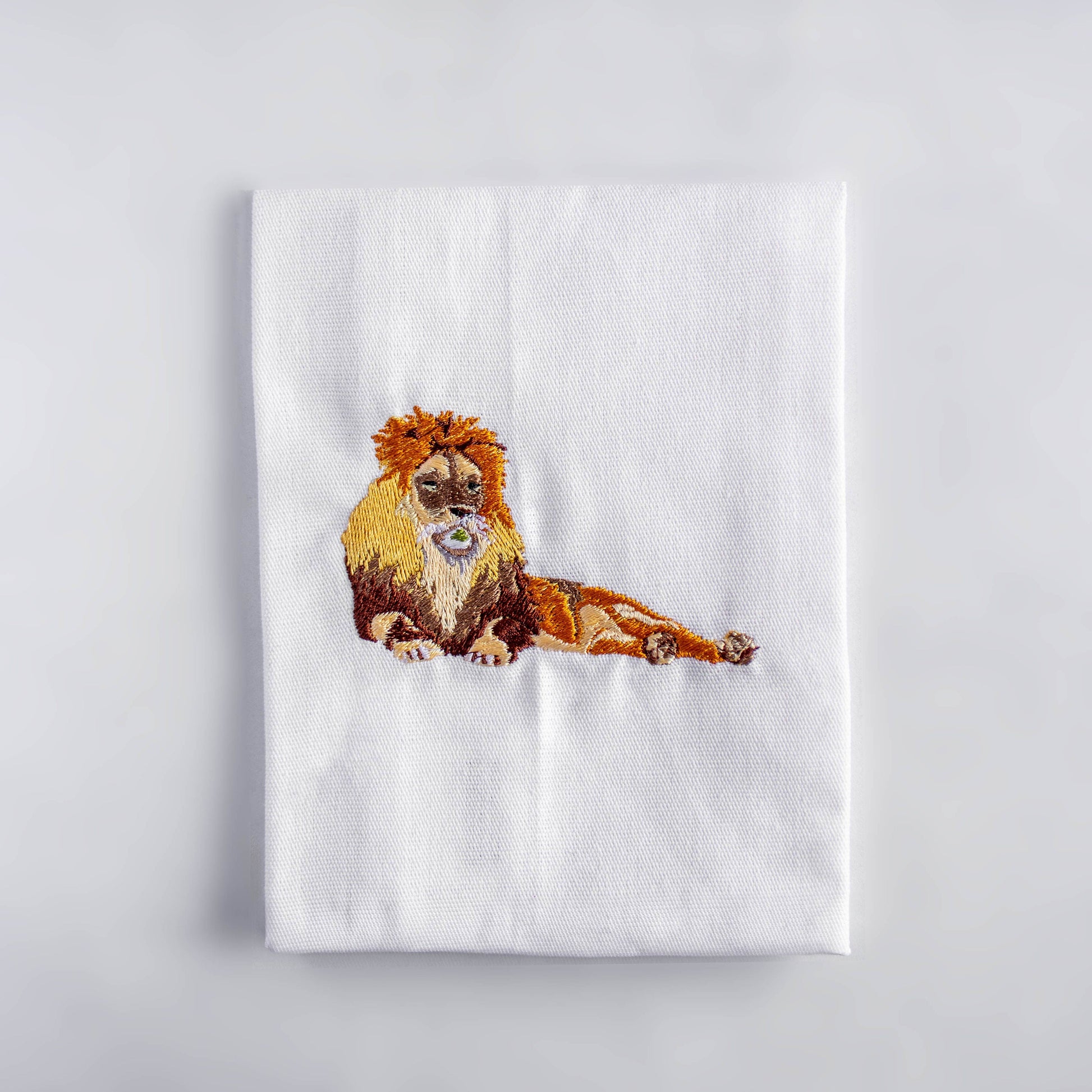Lion embroidered cotton cloth napkin flat lay on white surface — Ecodunia