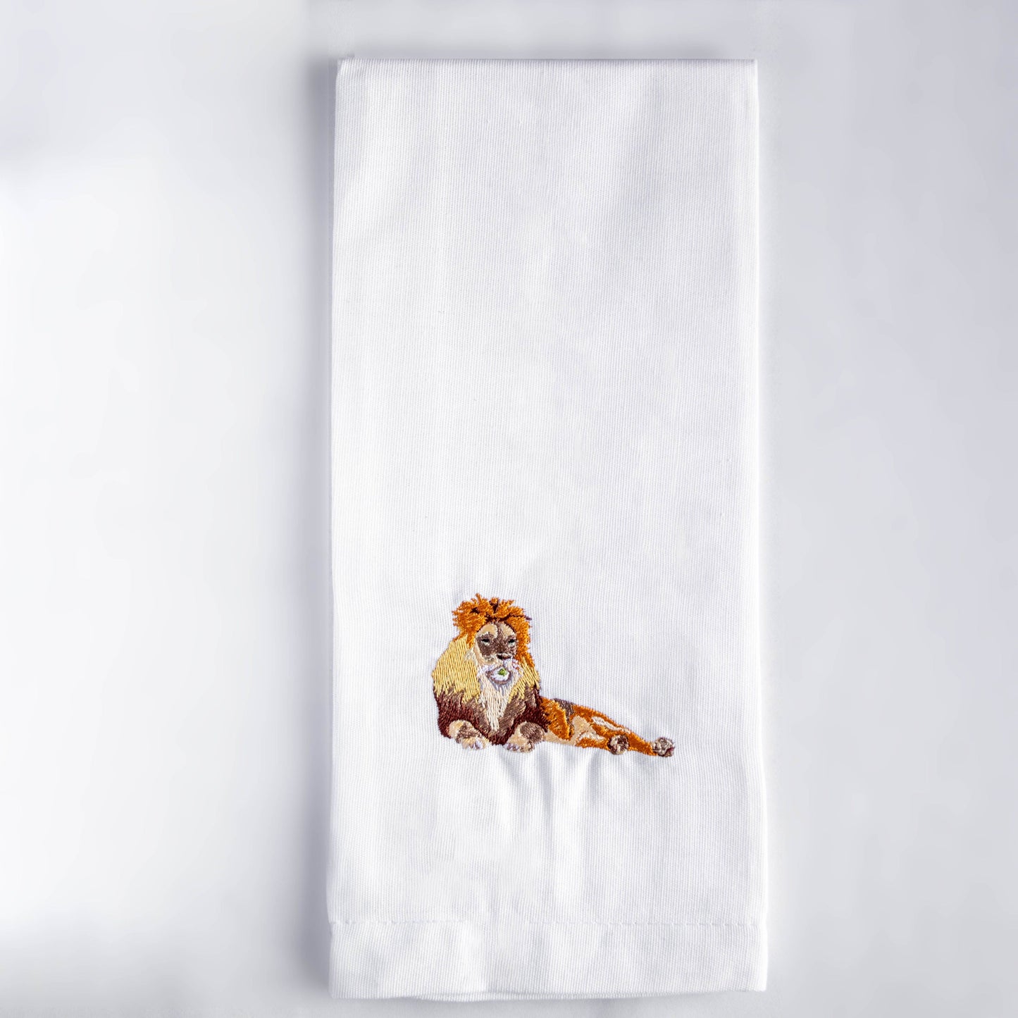 Lion embroidered cotton tea towel flat lay on white surface — Ecodunia