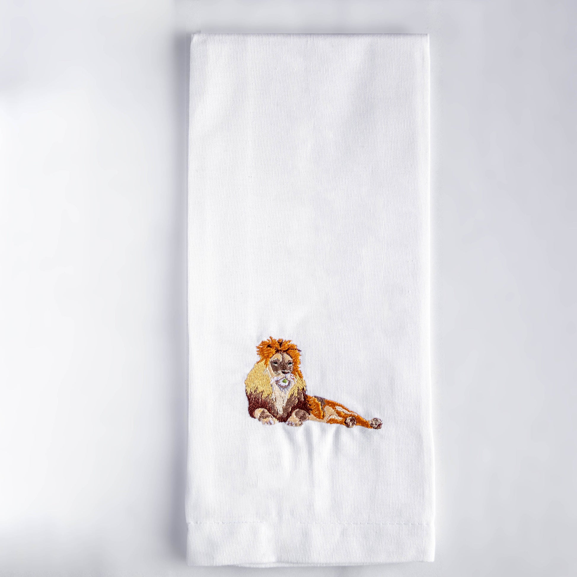 Lion embroidered cotton tea towel flat lay on white surface — Ecodunia
