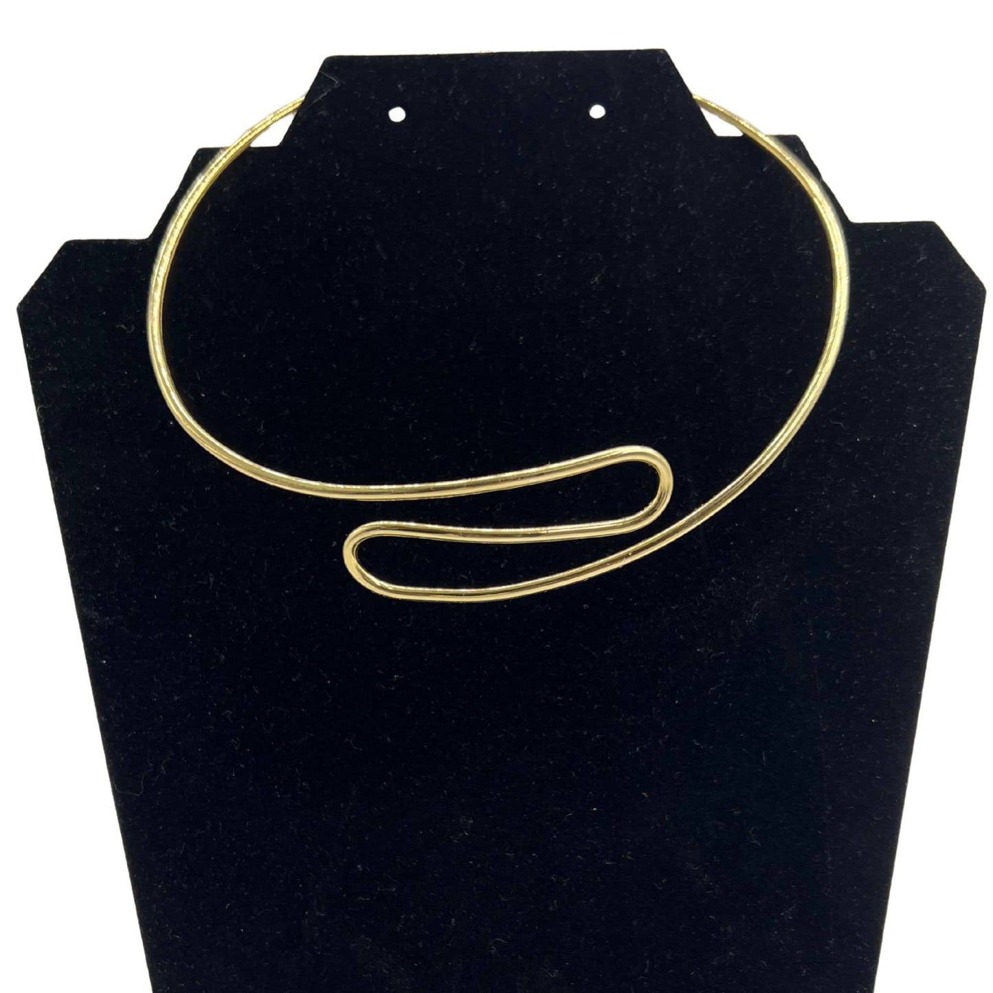 Milele spiral cuff brass choker necklace flat lay on warm surface — Ecodunia