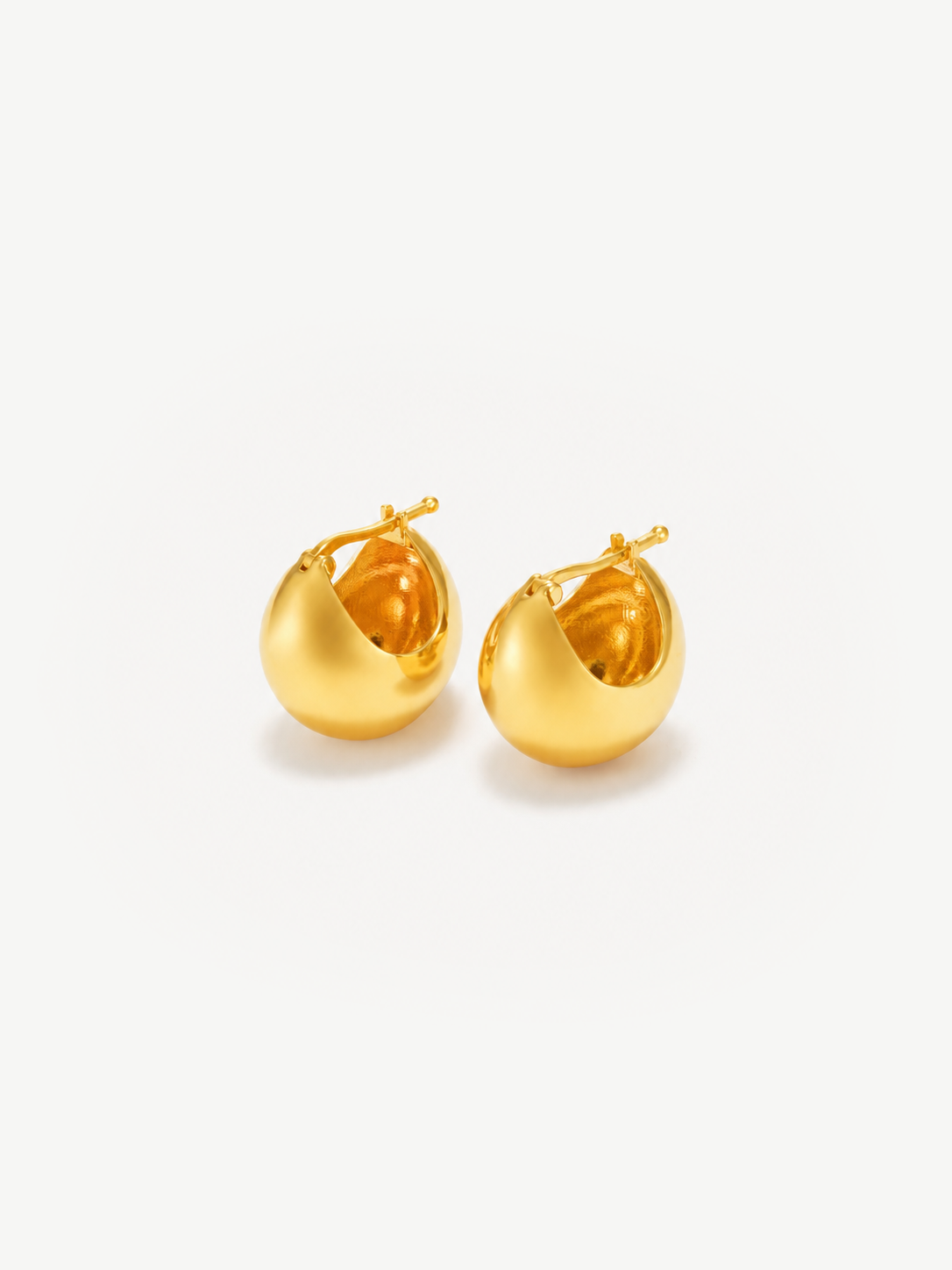 A pair of gold-toned, round-shaped hoop earrings with a smooth surface and post-back closures, displayed on a clean white background.