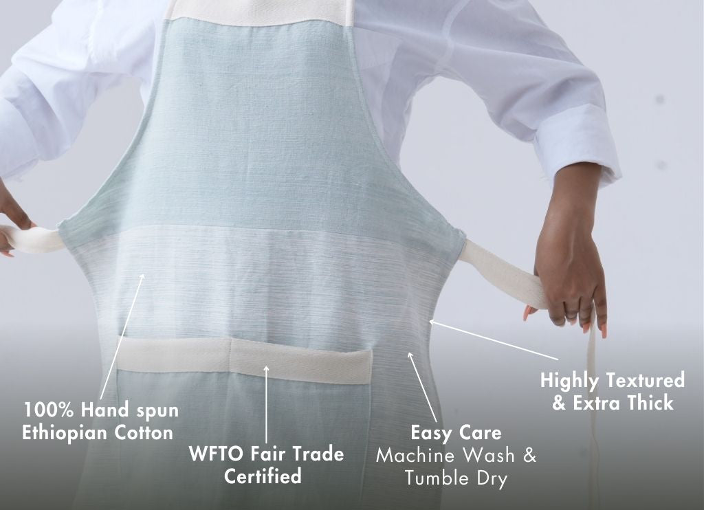 Person wearing a azurro megebi apron with text highlighting its features on a white background