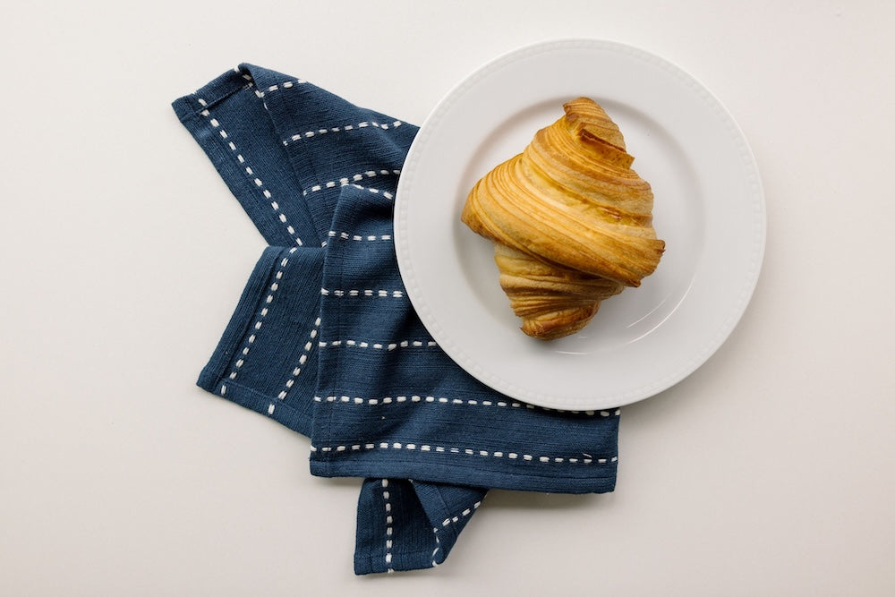 Rift Valley cocktail napkin in navy with a croissant