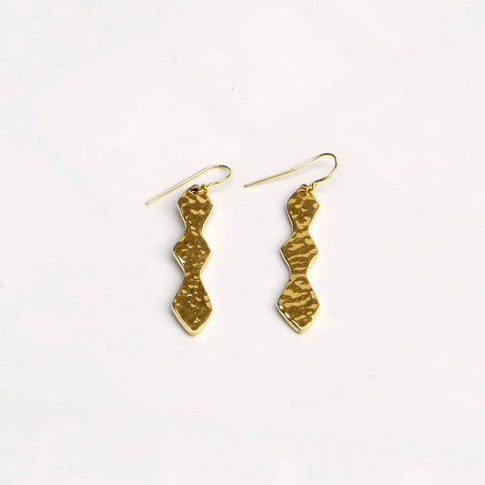 Rio hammered double hourglass brass dangle earrings flat lay — Ecodunia