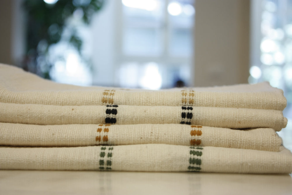 Stack of folded fabric with striped patterns on a blurred background