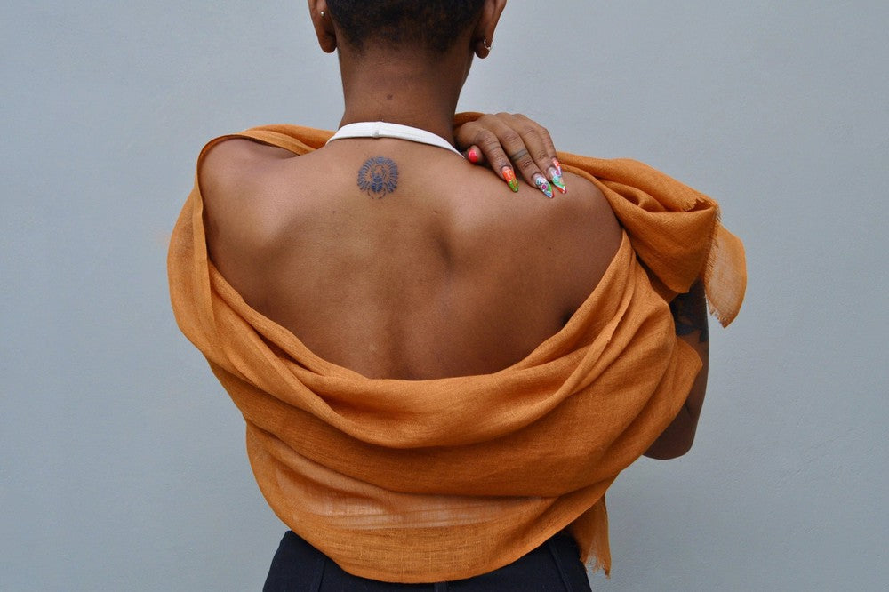 Telba linen shawl in bronze on a model from the back. 