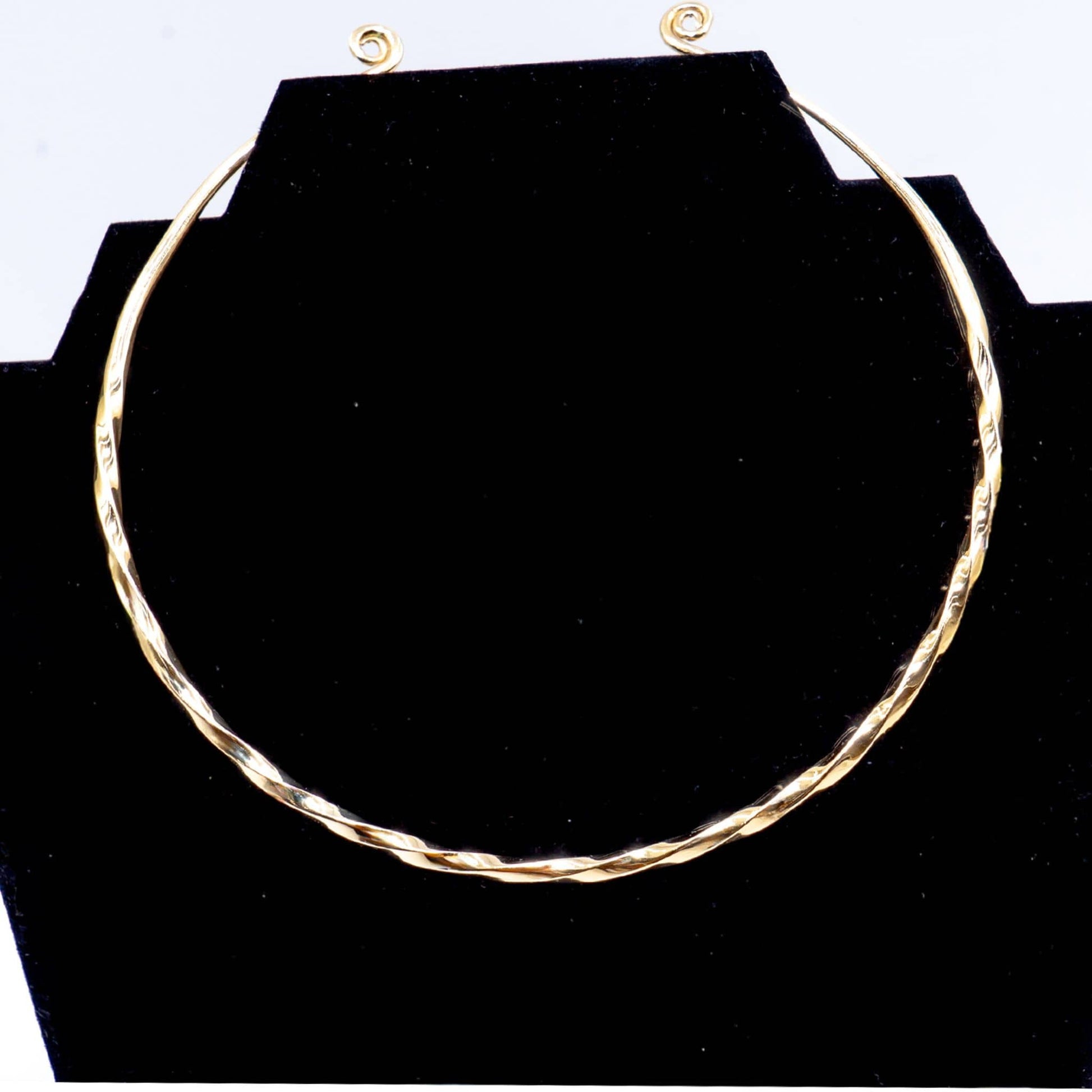 Uzi open collar brass choker necklace flat lay on warm surface — Ecodunia