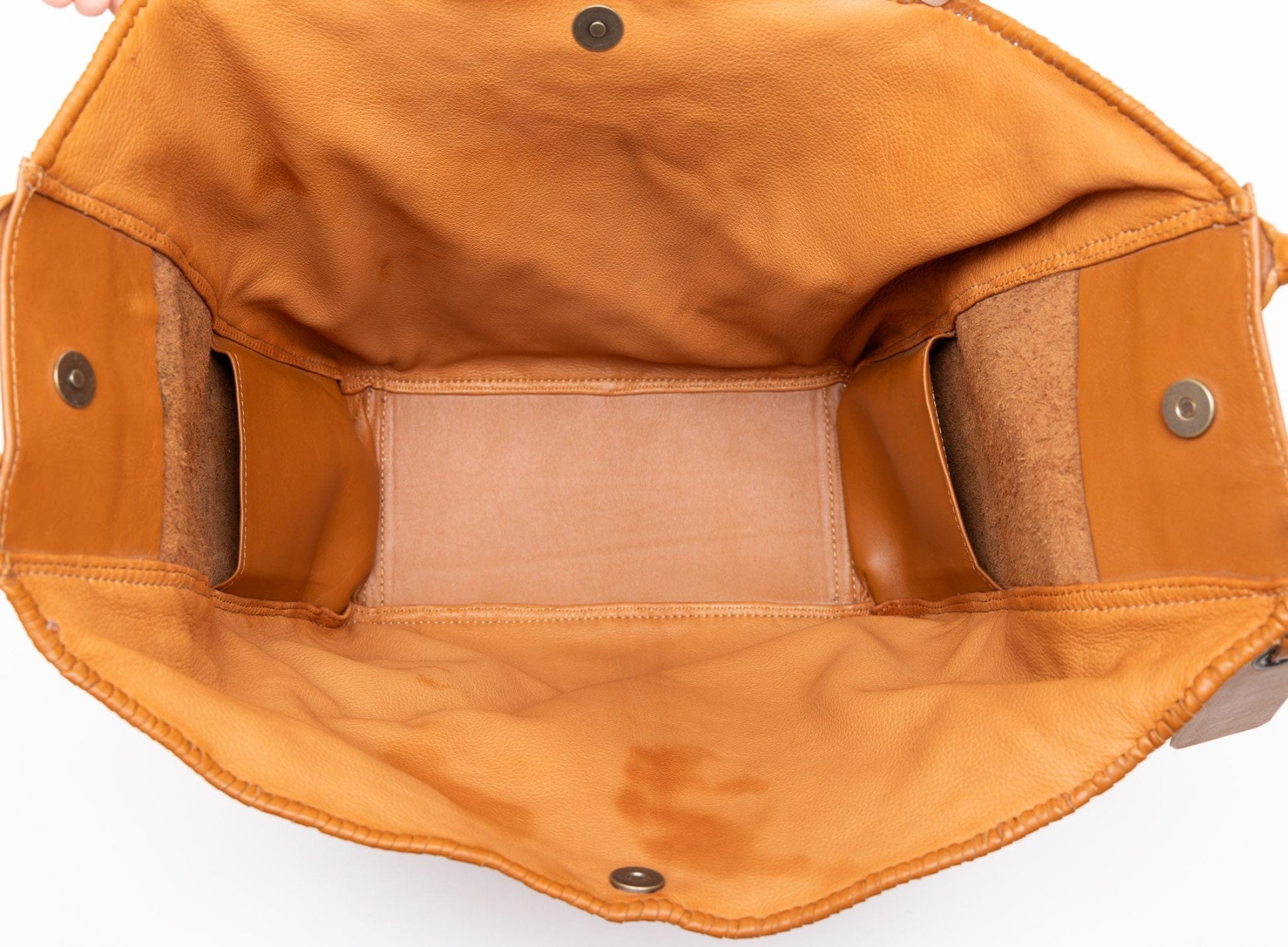 Close-up of a two-tone-camel  leather bag with visible stitching and hardware on a white background