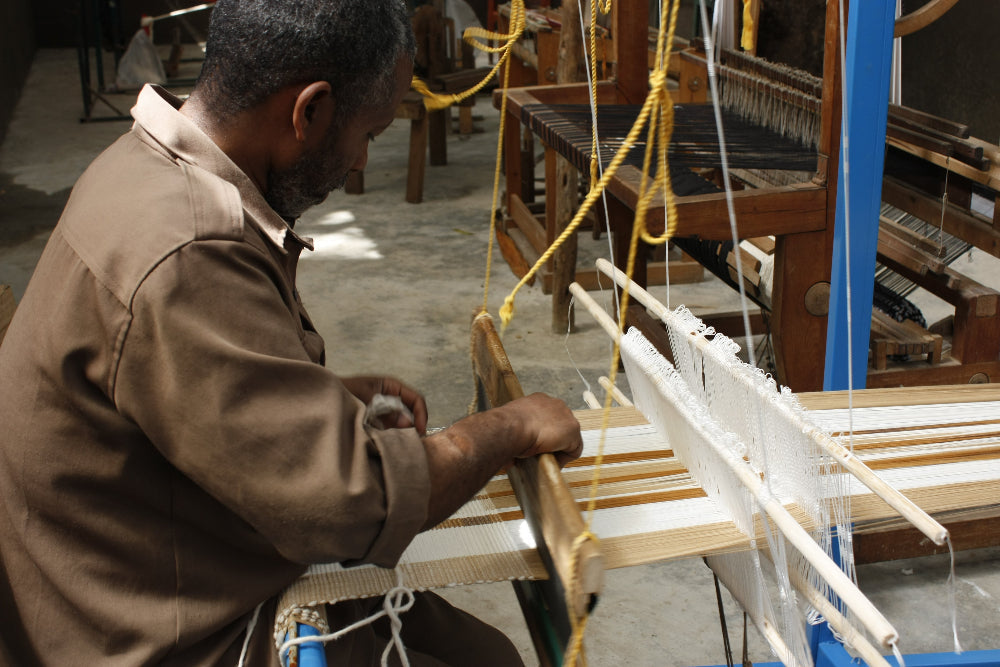 artisan weaving gonder table runner on traditional loom
