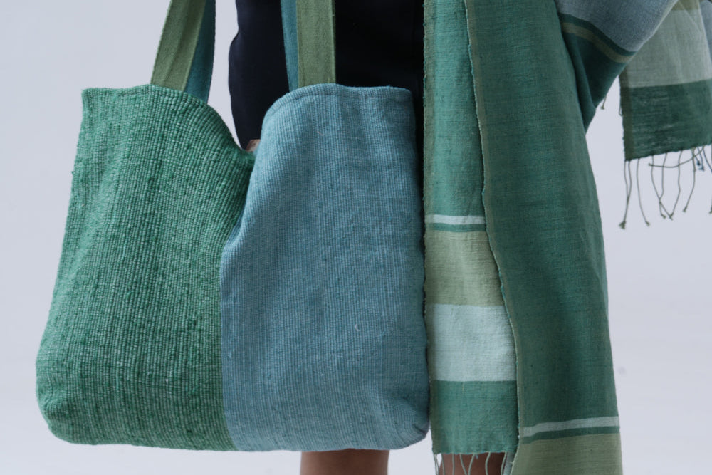 bolsa tote with mareb towel in teal carried by model on white background