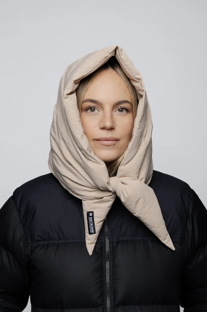 Light beige vegan winter capuche made from recycled materials, styled over black puffer jacket. - The New Orchard - Light Beige